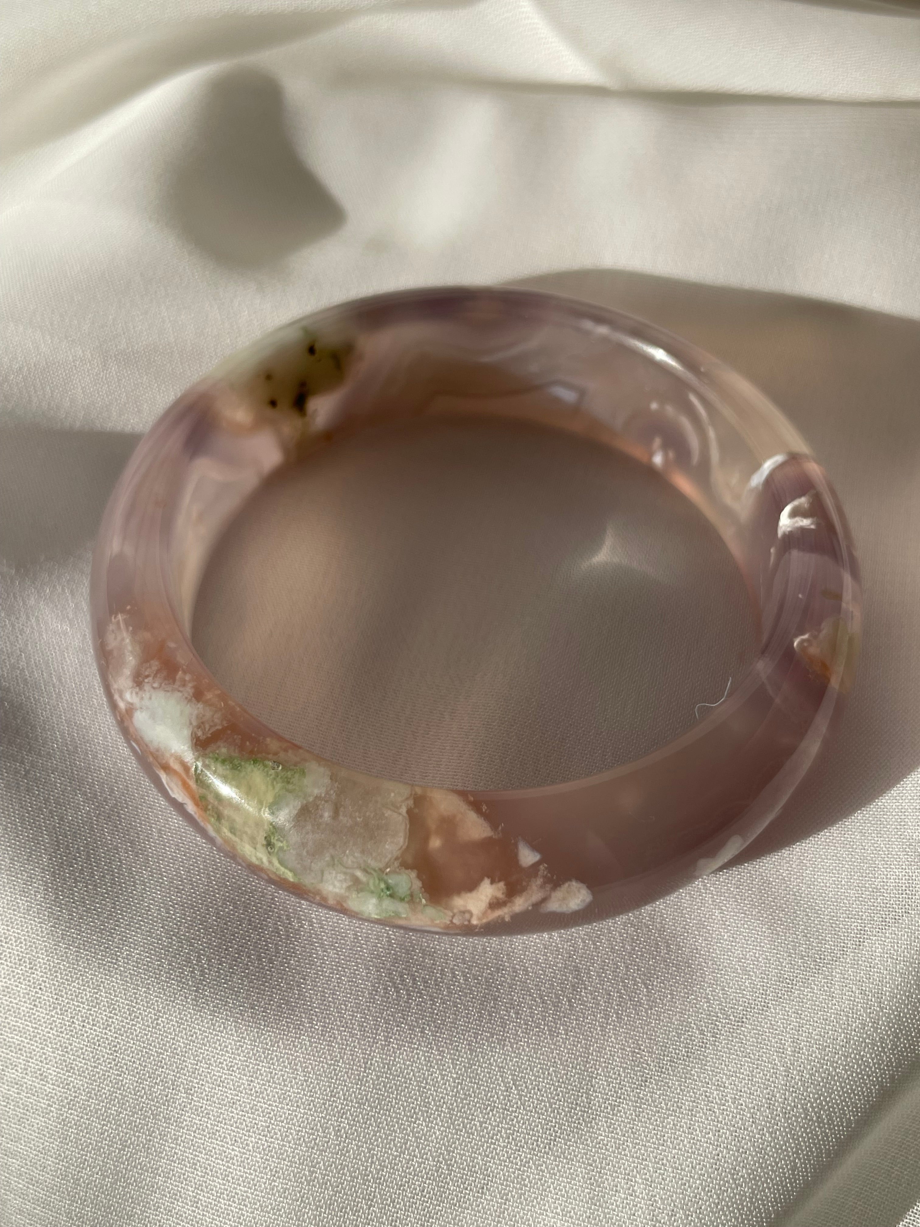 Beautiful flower agate bangle featuring soft pink and earthy tones, showcasing unique patterns and textures.