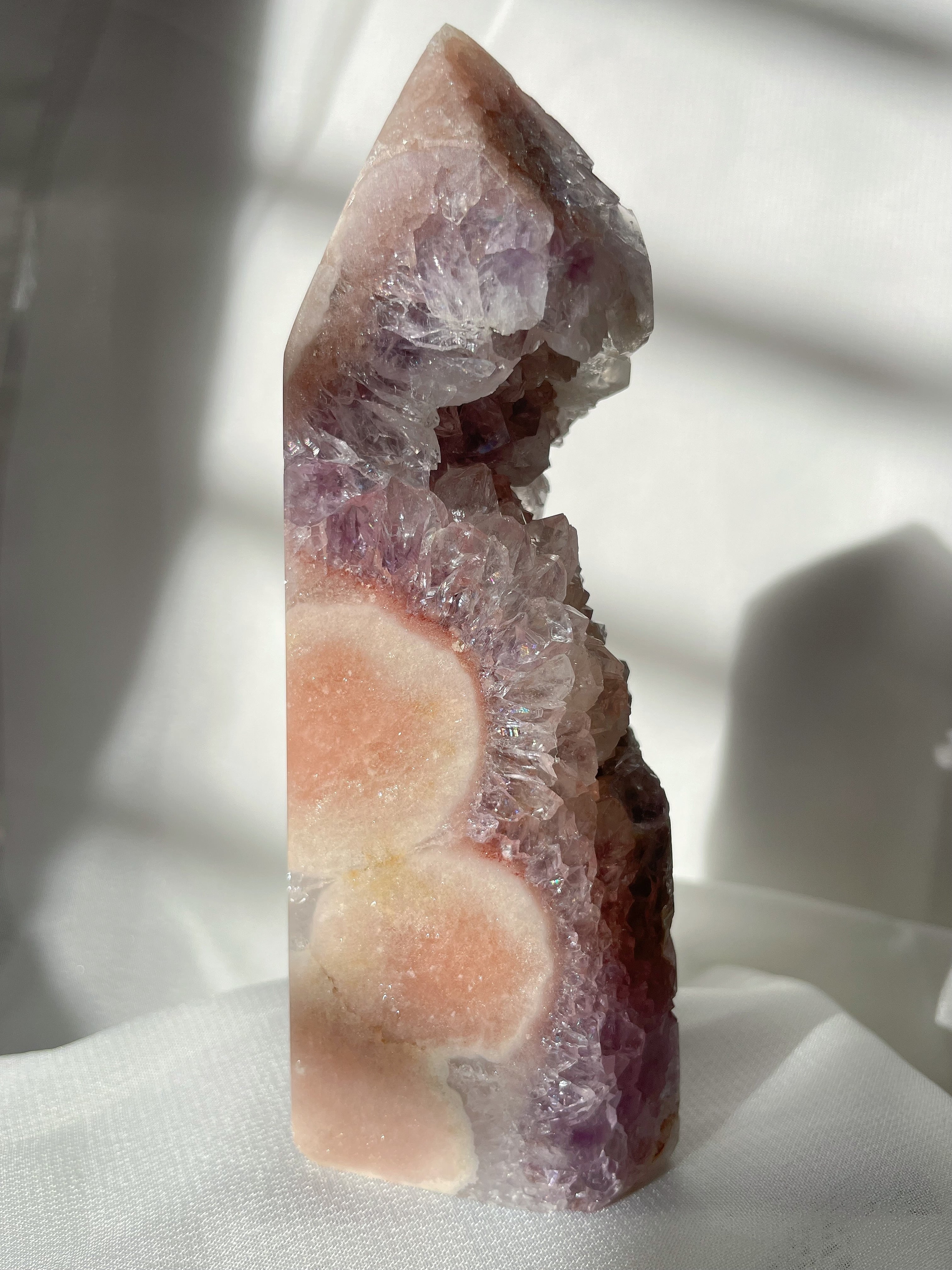 Stunning pink and purple amethyst crystal tower with natural formations and a glossy finish.