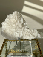 Beautiful petal bladed calcite specimen displayed on a clear stand, showcasing intricate crystal formations.