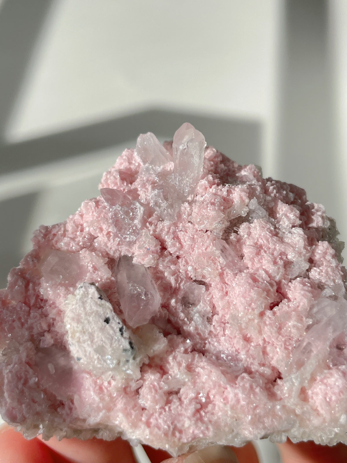 Beautiful rhodochrosite cluster with pink hues and sparkling crystal formations, showcasing natural mineral beauty.