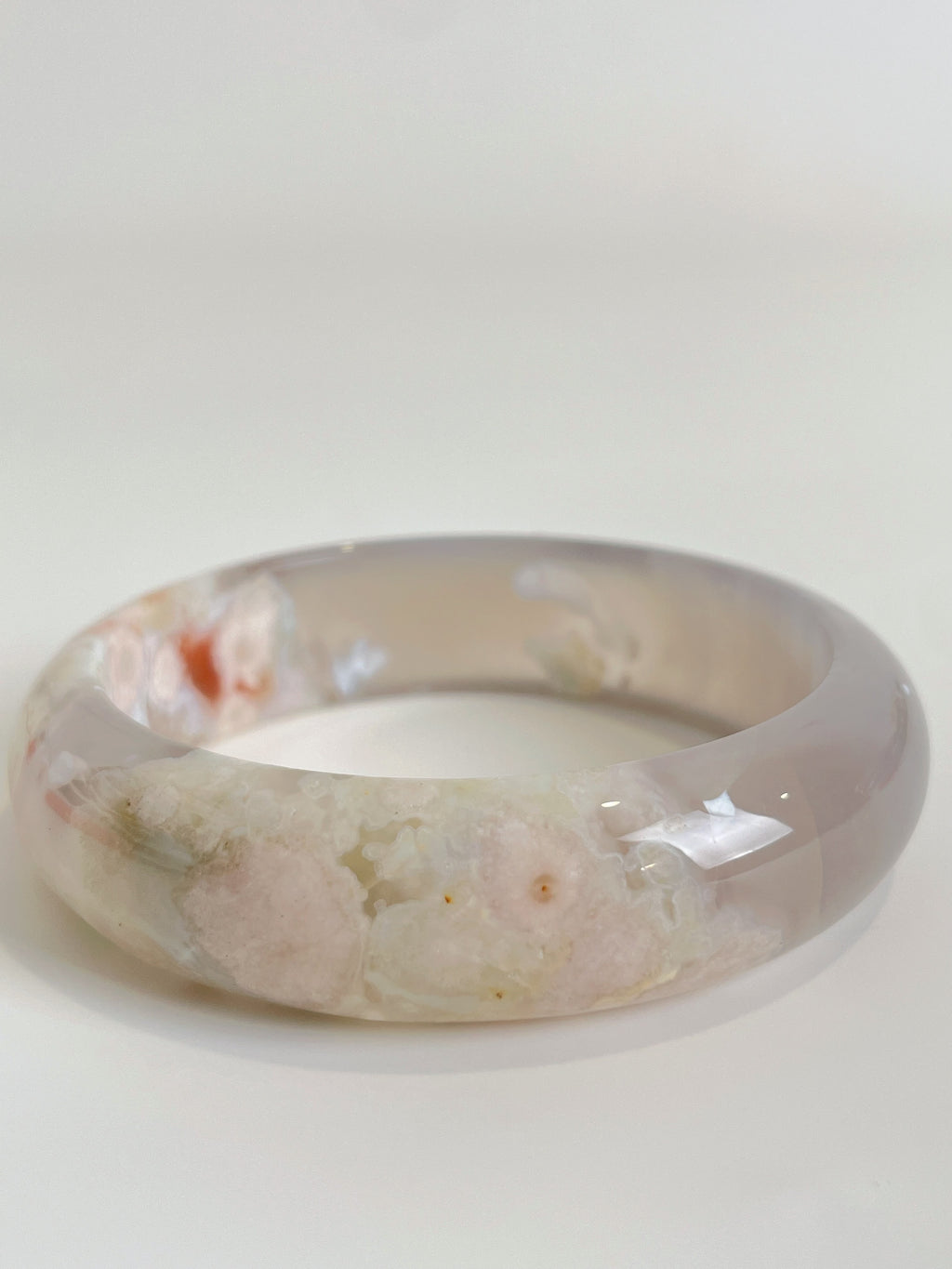 Beautiful flower agate bangle showcasing soft pink and cream hues with floral patterns, perfect for stylish wear.