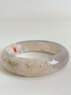 Beautiful flower agate bangle showcasing soft pink and cream hues with floral patterns, perfect for stylish wear.