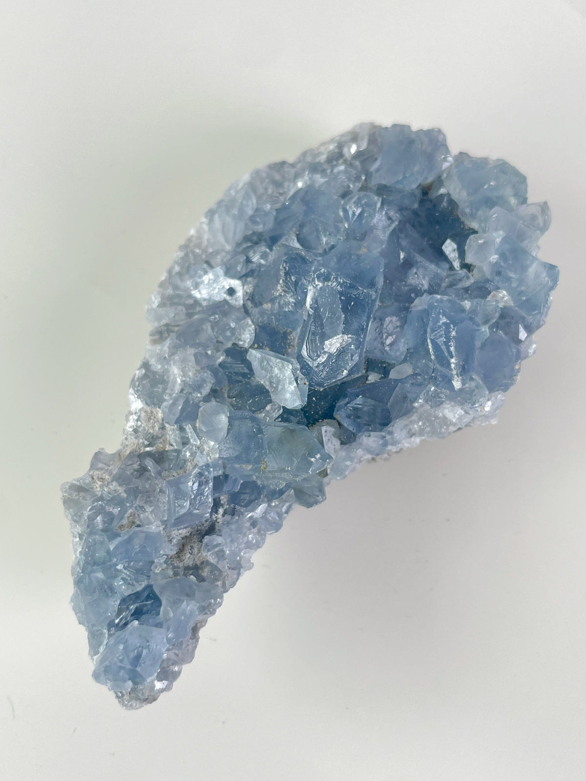 A stunning Madagascar celestite cluster featuring light blue, sparkling crystal formations.
