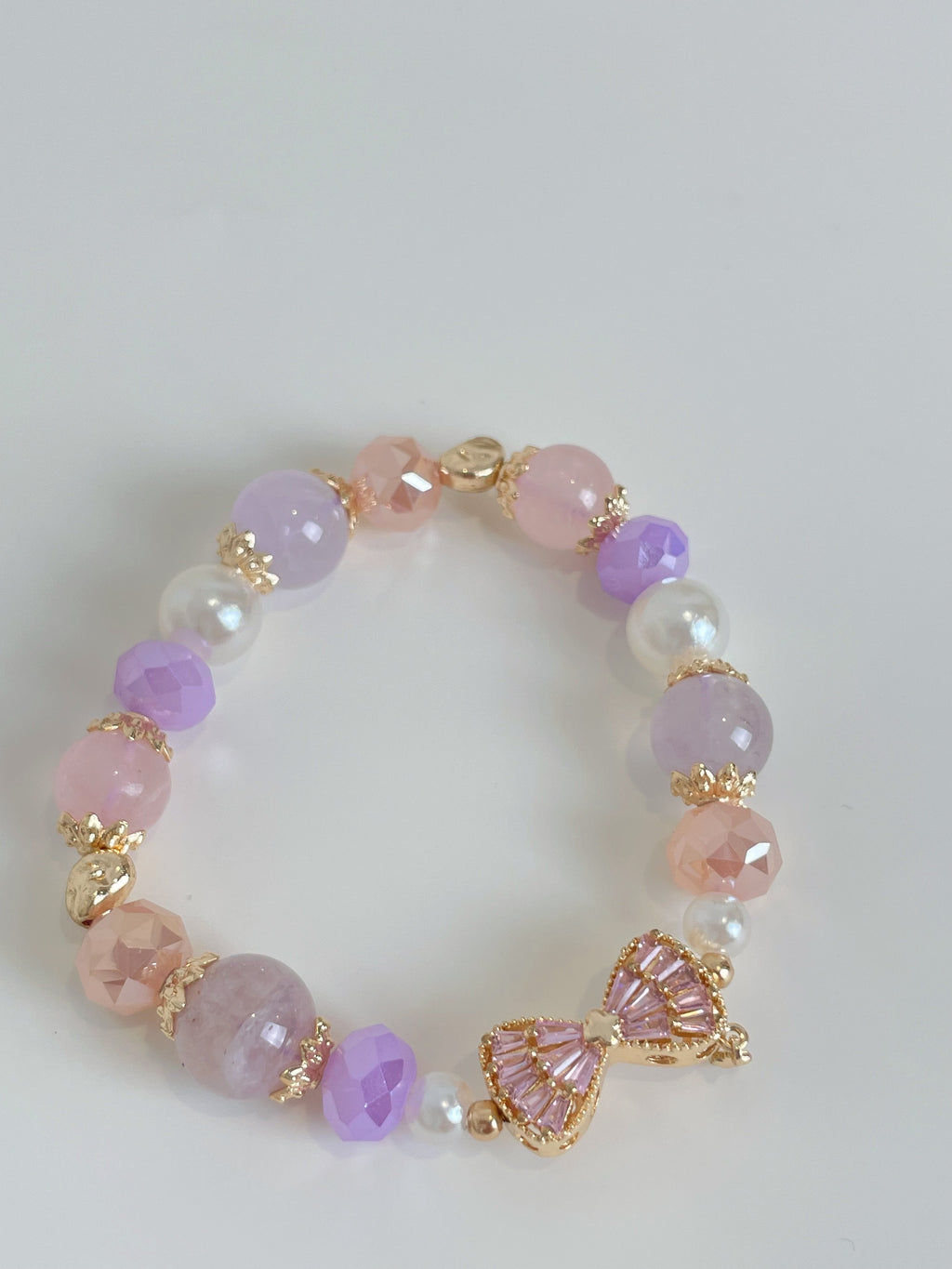 Beautiful bracelet featuring pink amethyst and rose quartz beads, accented with gold and pearl details.
