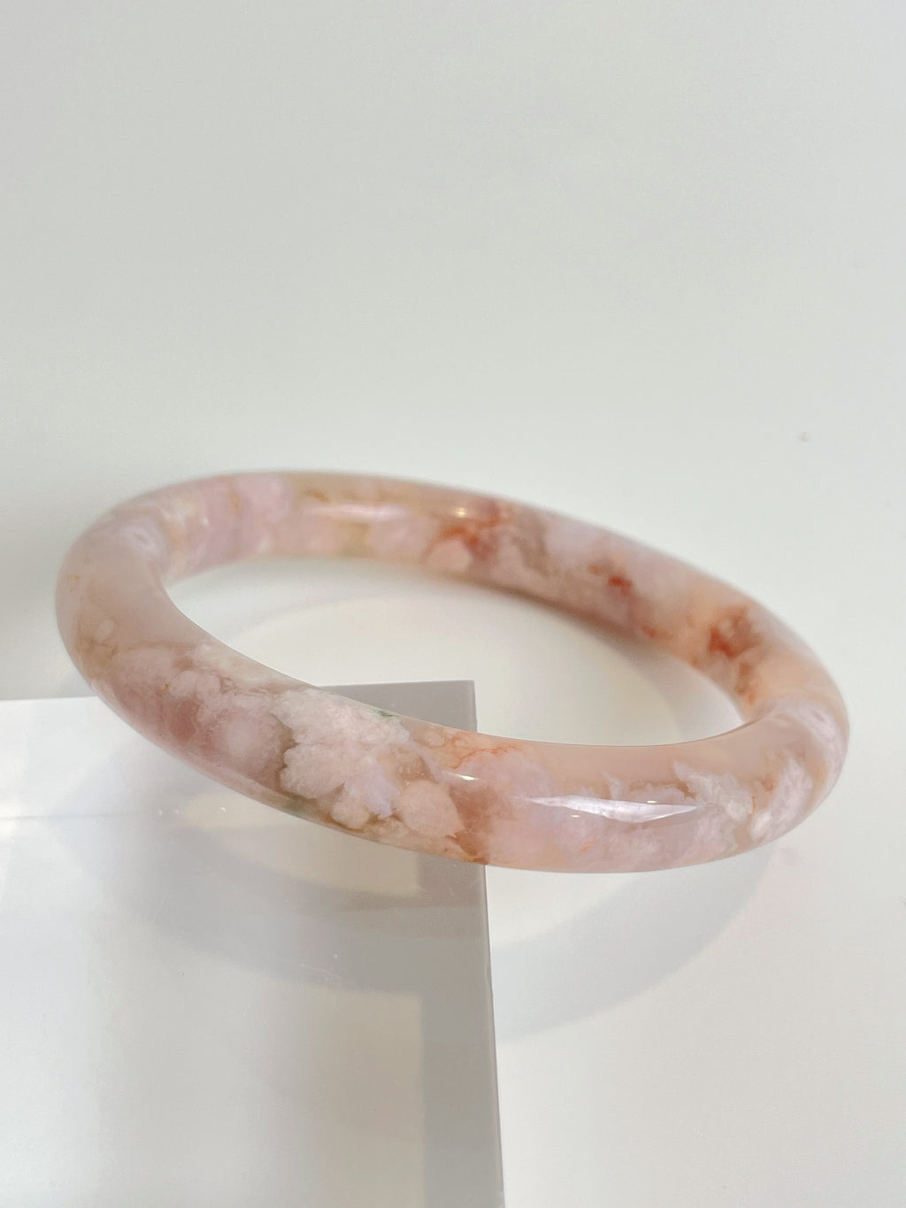 Beautiful flower agate bangle with soft pink hues and floral patterns, showcasing a smooth, glossy finish.