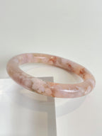 Beautiful flower agate bangle with soft pink hues and floral patterns, showcasing a smooth, glossy finish.