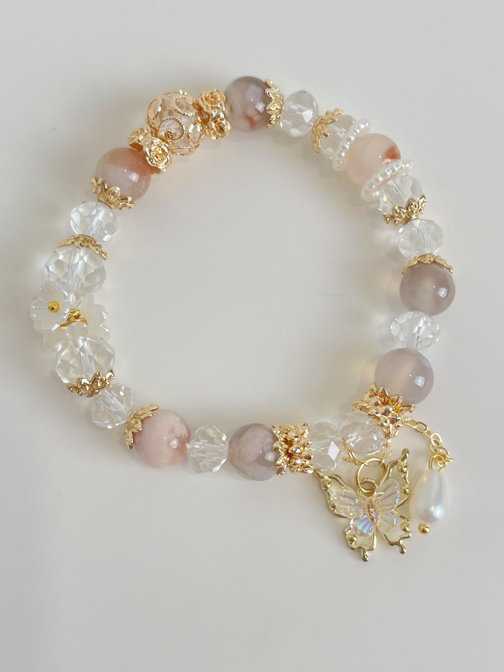 Beautiful flower agate bracelet featuring pink and clear crystal beads, adorned with a delicate butterfly charm.