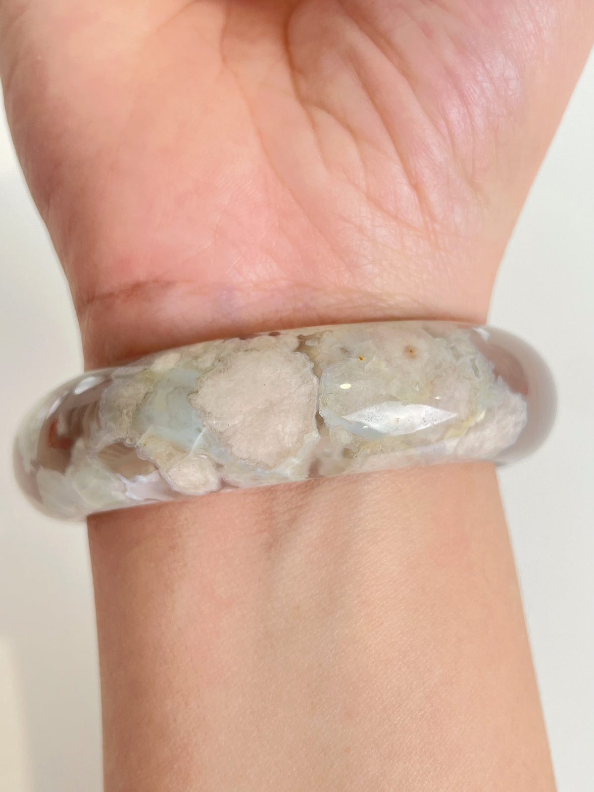 Flower agate bangle featuring delicate floral patterns, showcasing beautiful crystal details on a wrist.
