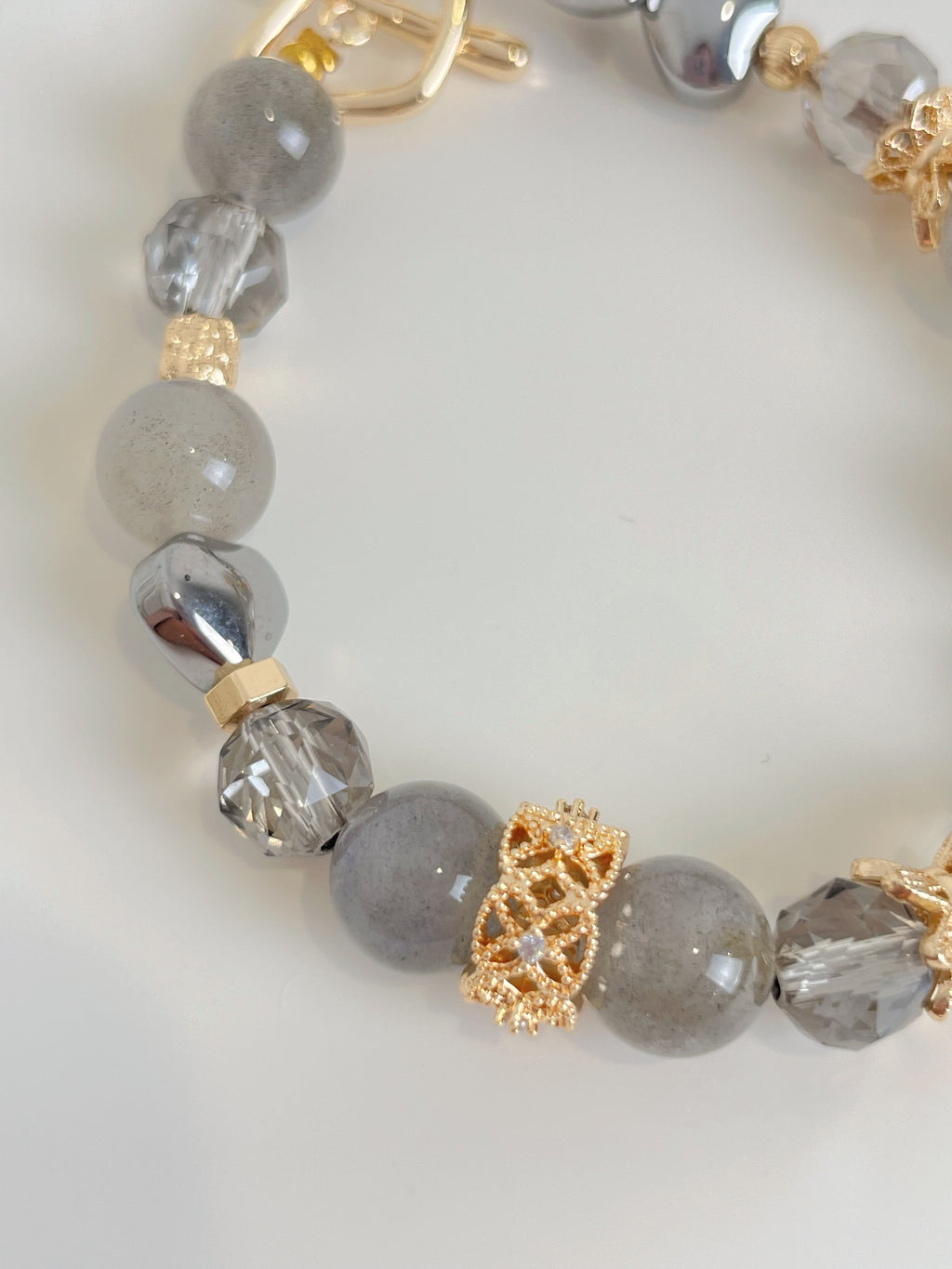 Labradorite bracelet featuring 9mm beads in shades of gray with decorative gold accents and sparkling crystal elements.