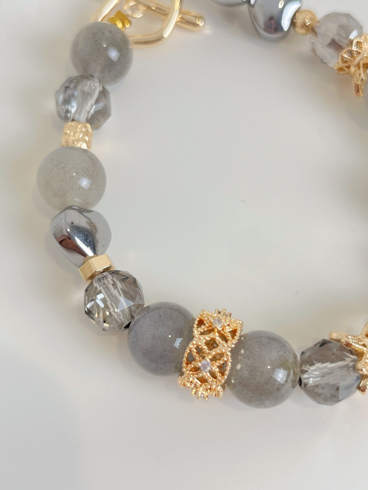 Labradorite bracelet featuring 9mm beads in shades of gray with decorative gold accents and sparkling crystal elements.