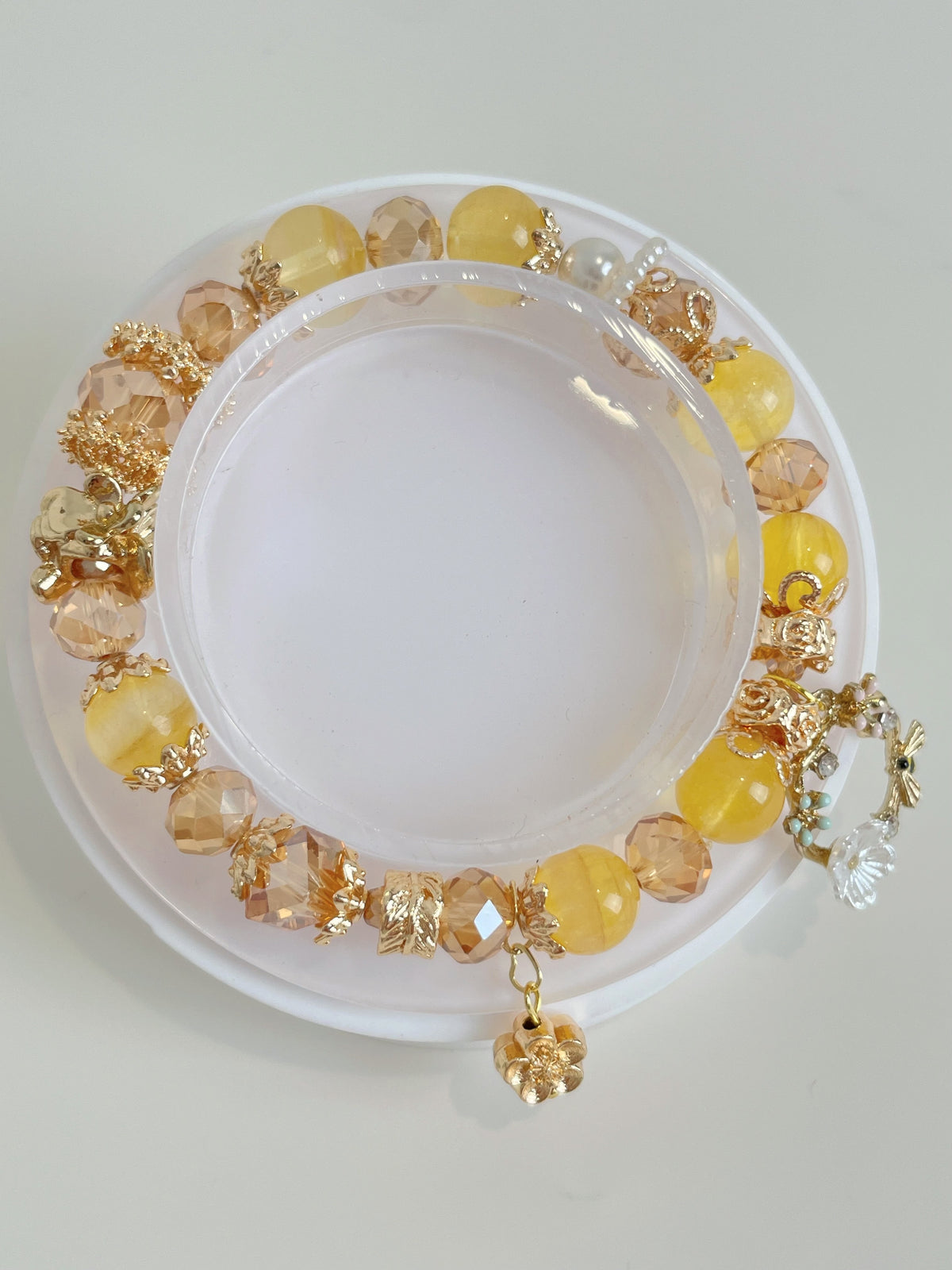 A vibrant yellow fluorite bracelet featuring 9mm beads, accented with golden and clear embellishments.