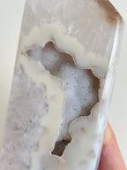 Druzy agate tower with a beautiful, translucent surface revealing sparkling crystal formations inside.