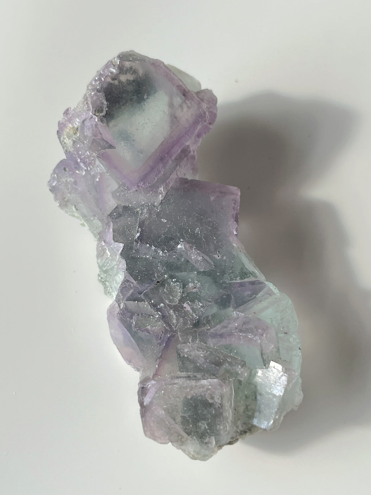 Beautiful fluorite crystal specimen featuring shades of purple and green, showcasing natural formations.