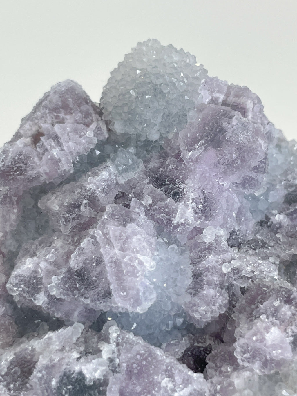 Beautiful crystal specimen of sugar fluorite with a mix of purple and clear hues, showcasing intricate textures.