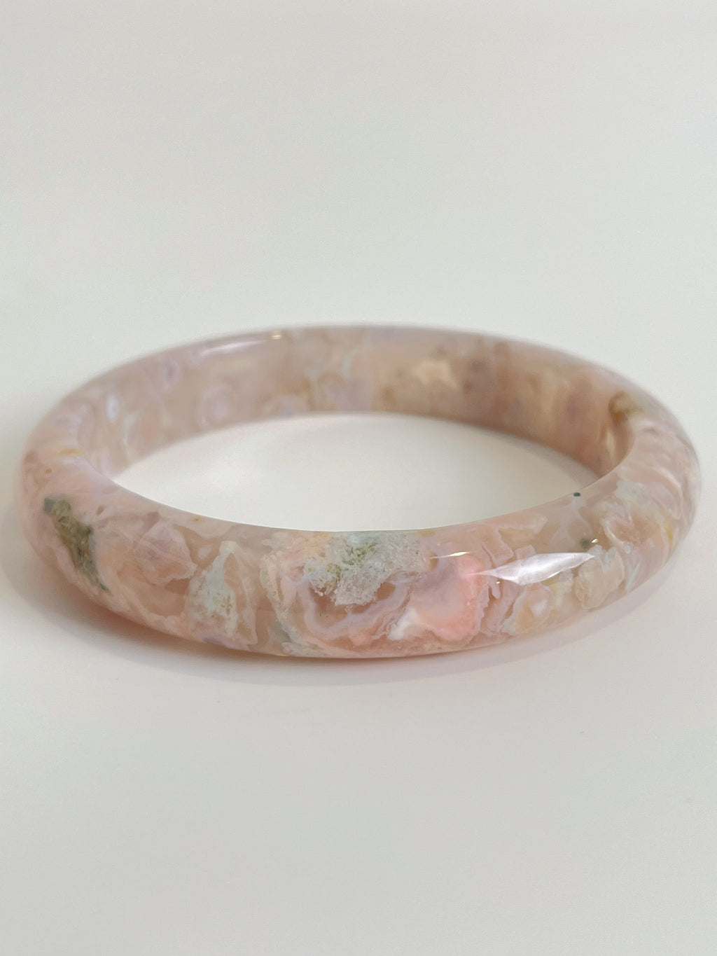 Beautiful flower agate bangle with soft pink hues and natural patterns, showcasing its unique crystal design.