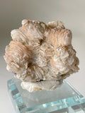 Beautiful bladed petal calcite specimen with delicate layers, displayed on a clear pedestal.