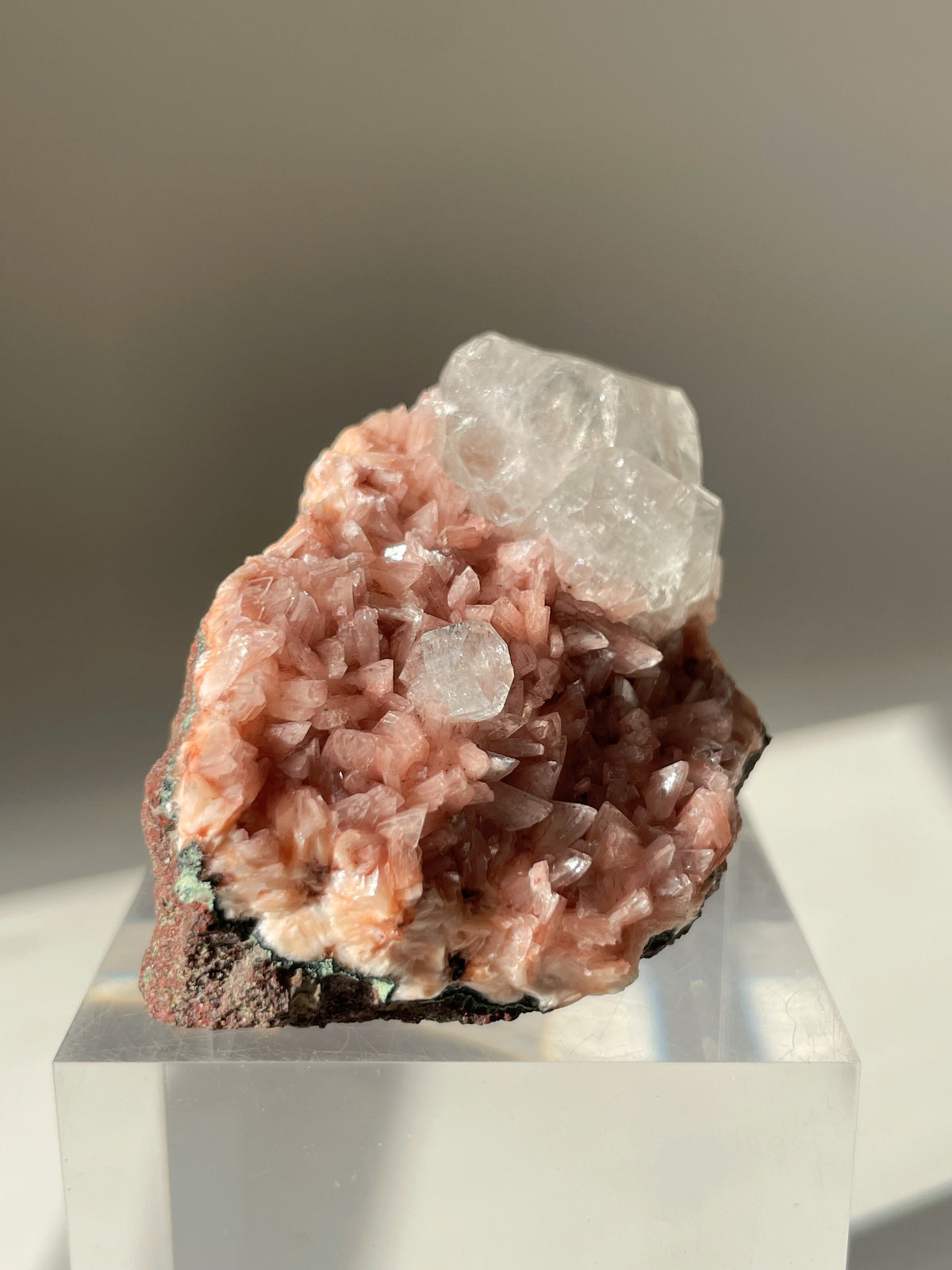 Beautiful pink Heulandite and Apophyllite crystal specimen on a clear display stand, showcasing its natural beauty.