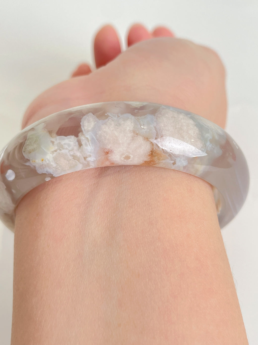 Beautiful flower agate bangle resting on a wrist, showcasing its unique patterns and soft colors.