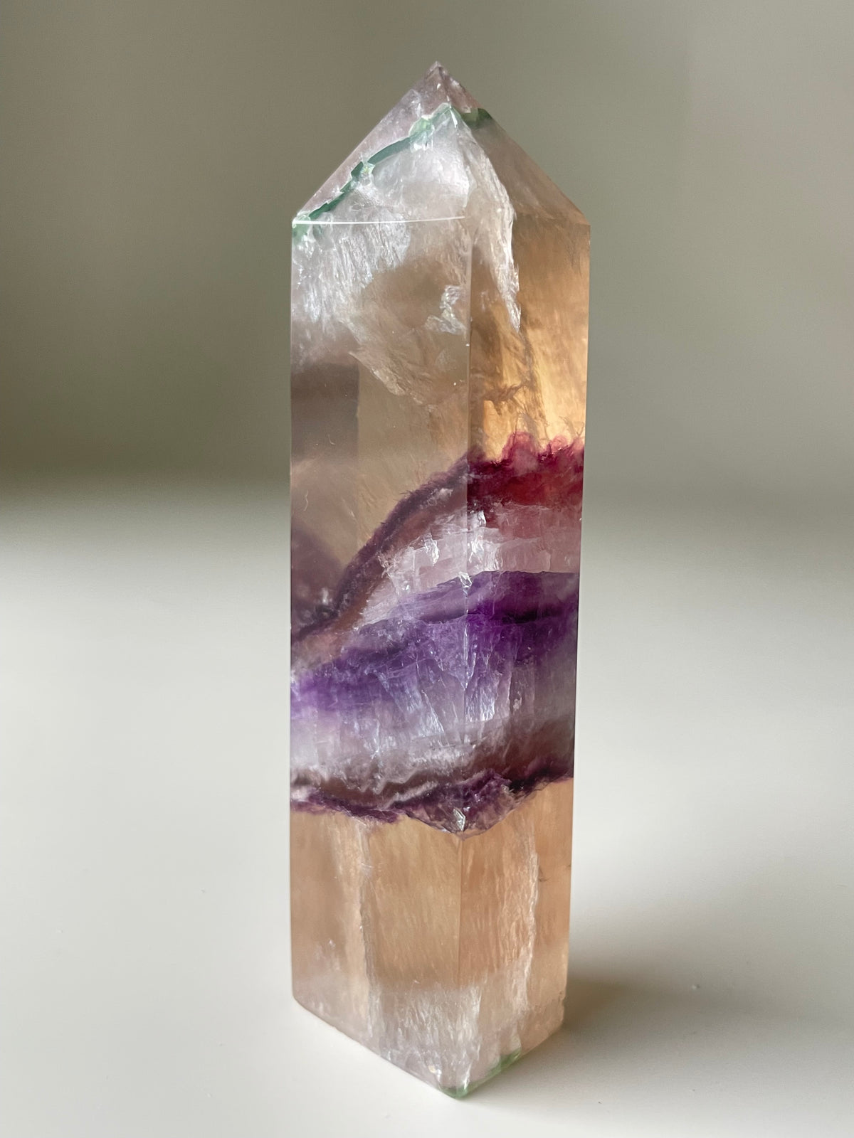 Rare banded fluorite tower showcasing vibrant purple and green bands, beautifully polished and reflective.