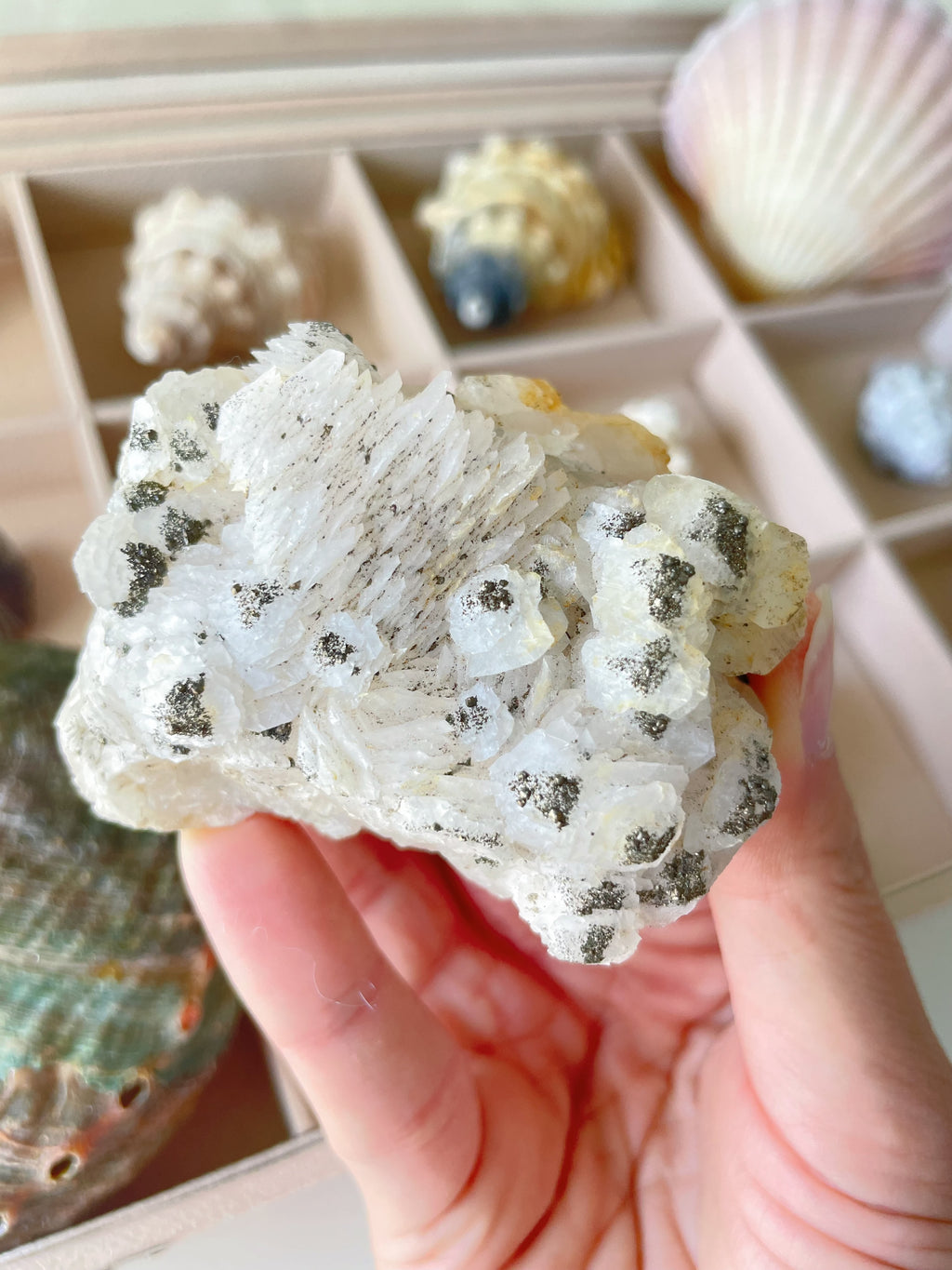 Beautiful pyrite on pagoda calcite specimen held in hand, showcasing intricate textures and natural formations.