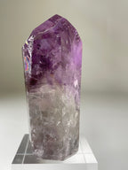 A stunning Brazilian Phantom Amethyst Tower with vibrant purple hues and clear facets, displayed elegantly.
