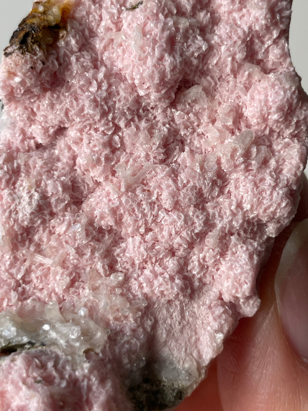 Rhodochrosite cluster with a soft pink hue, showcasing delicate crystal formations and textures.