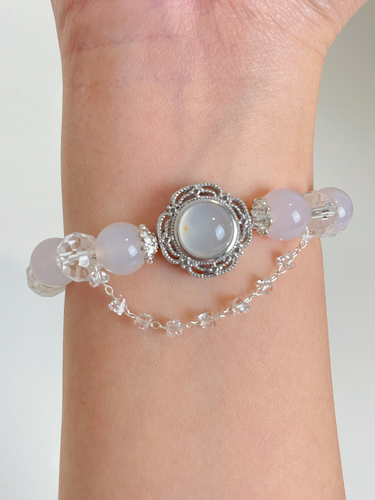 Elegant white agate bracelet featuring a central decorative element and sparkling crystal accents.