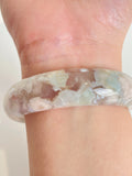 Beautiful flower agate bangle showcasing soft pastel colors and intricate patterns, worn on a wrist.