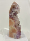 Beautiful pink and purple amethyst crystal tower with natural formations and a smooth finish.