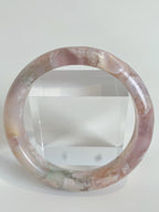 Beautiful flower agate bangle showcasing soft pink hues and natural patterns, displayed against a clear background.