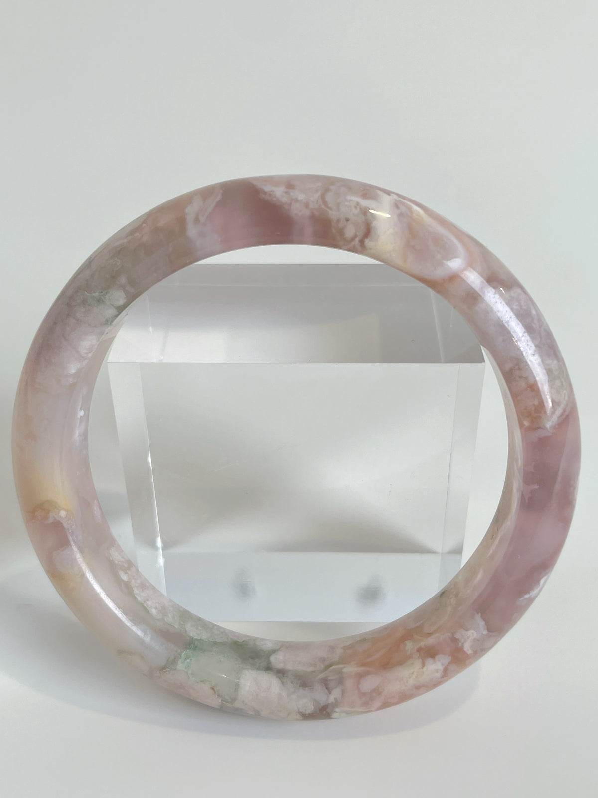 Beautiful flower agate bangle showcasing soft pink hues and natural patterns, displayed against a clear background.