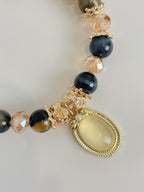 Blue Tiger's Eye Bracelet featuring 8.5mm beads with decorative gold accents and a central gemstone pendant.