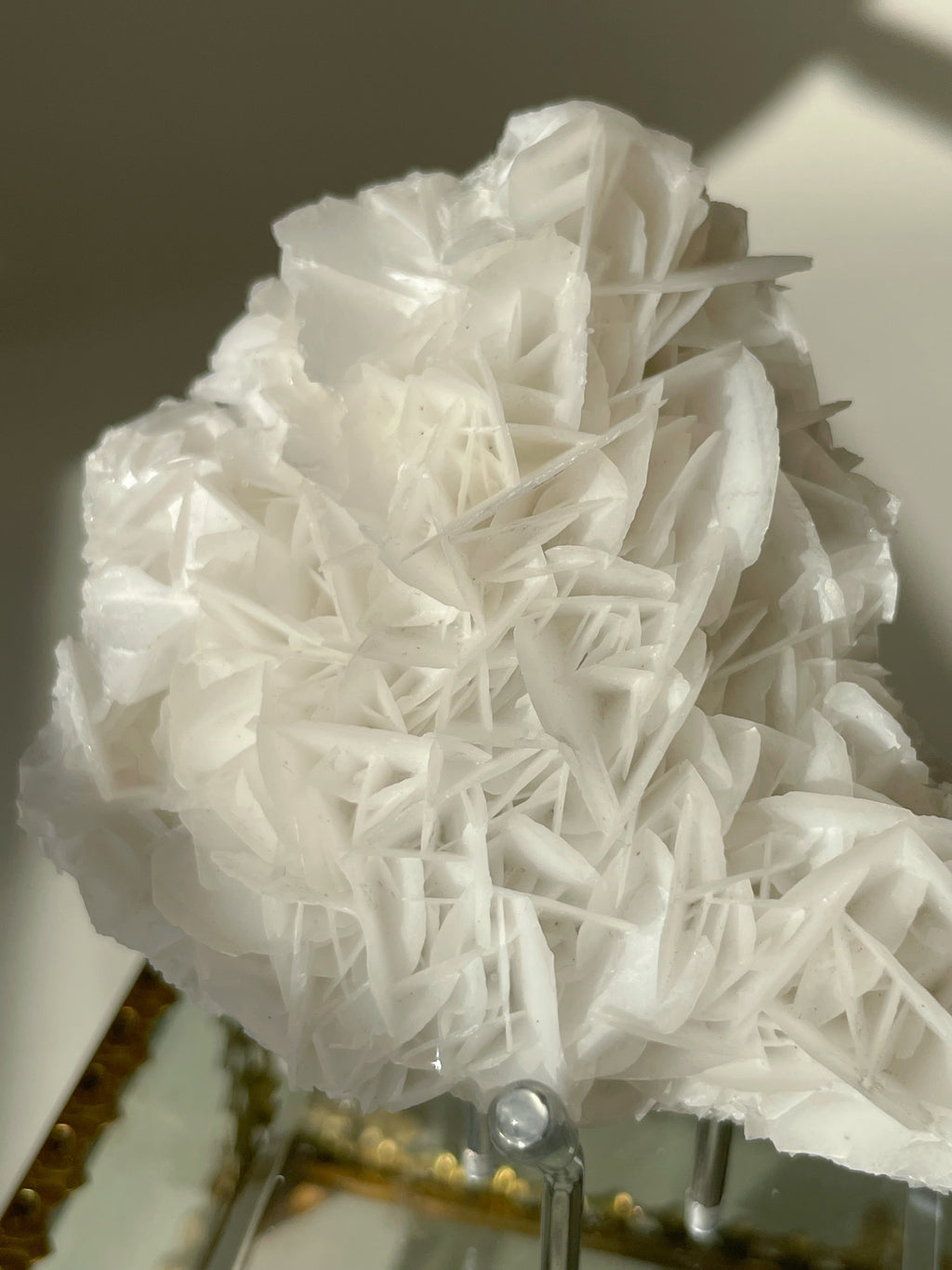 Beautiful petal bladed calcite specimen with intricate layered formations, displayed elegantly on a stand.