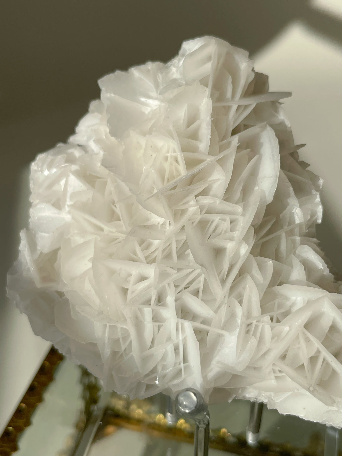 Beautiful petal bladed calcite specimen with intricate layered formations, displayed elegantly on a stand.