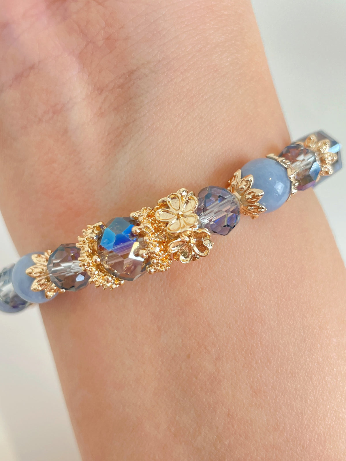Elegant Angelite bracelet featuring 8.5mm beads, adorned with sparkling gold floral accents and crystal details.