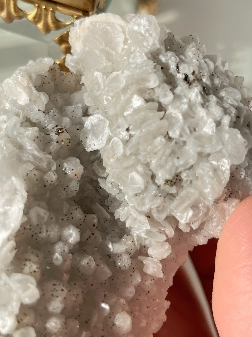 Beautiful crystal specimen featuring sparkling quartz with pyrite and calcite accents, held gently in hand.