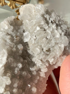 Beautiful crystal specimen featuring sparkling quartz with pyrite and calcite accents, held gently in hand.