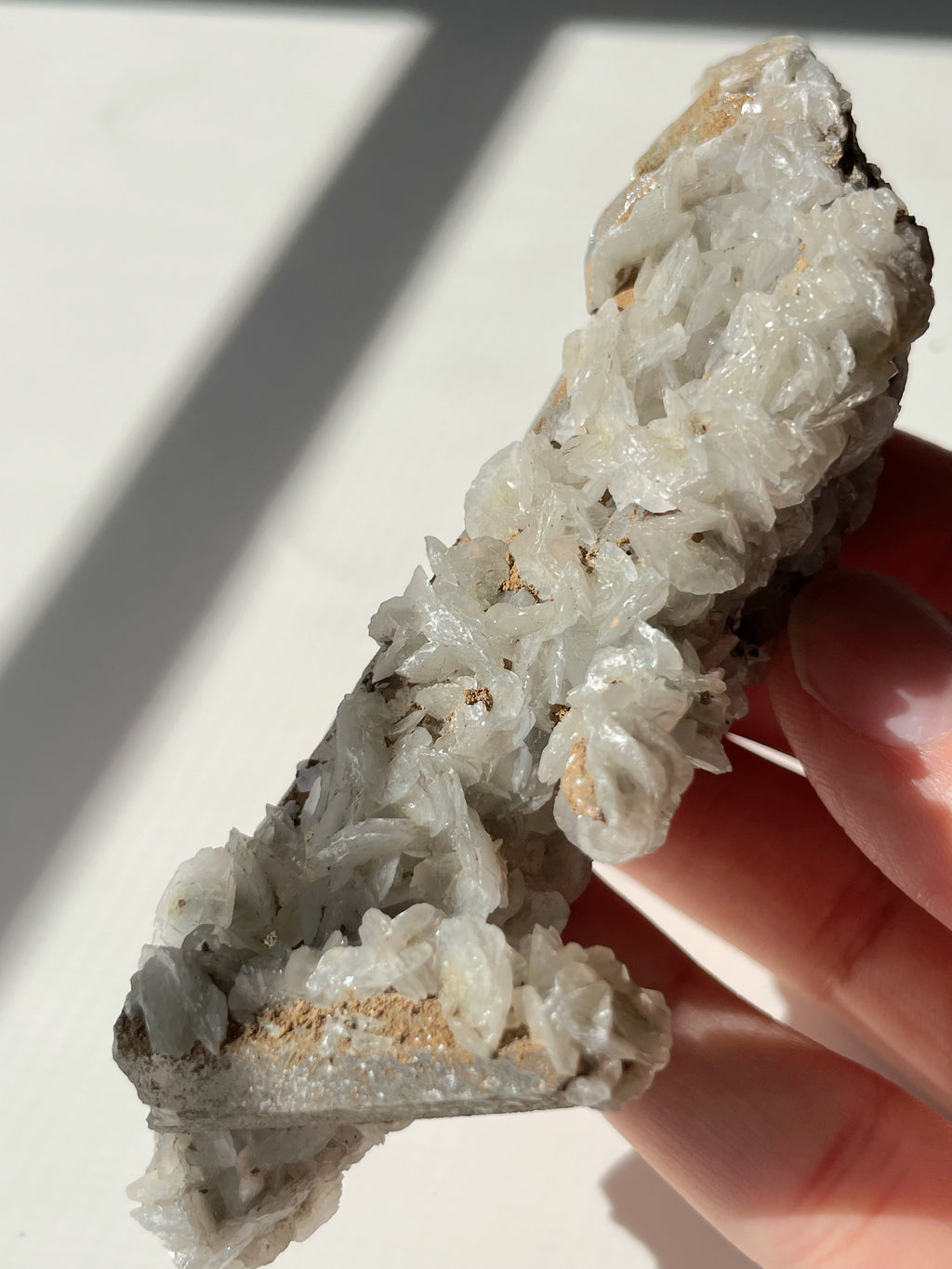 Beautiful crystal specimen featuring flower calcite on chlorite-included quartz, held in hand.