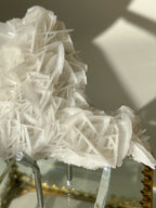 Beautiful petal bladed calcite specimen with intricate layered formations, displayed elegantly on a stand.