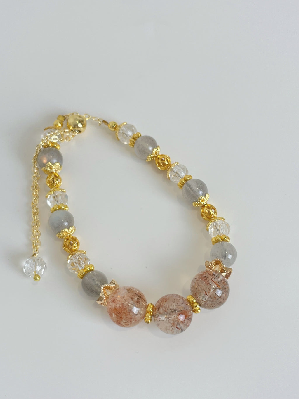 Beautiful rutilated quartz bracelet featuring 7-10mm beads with gold accents and a secure clasp.