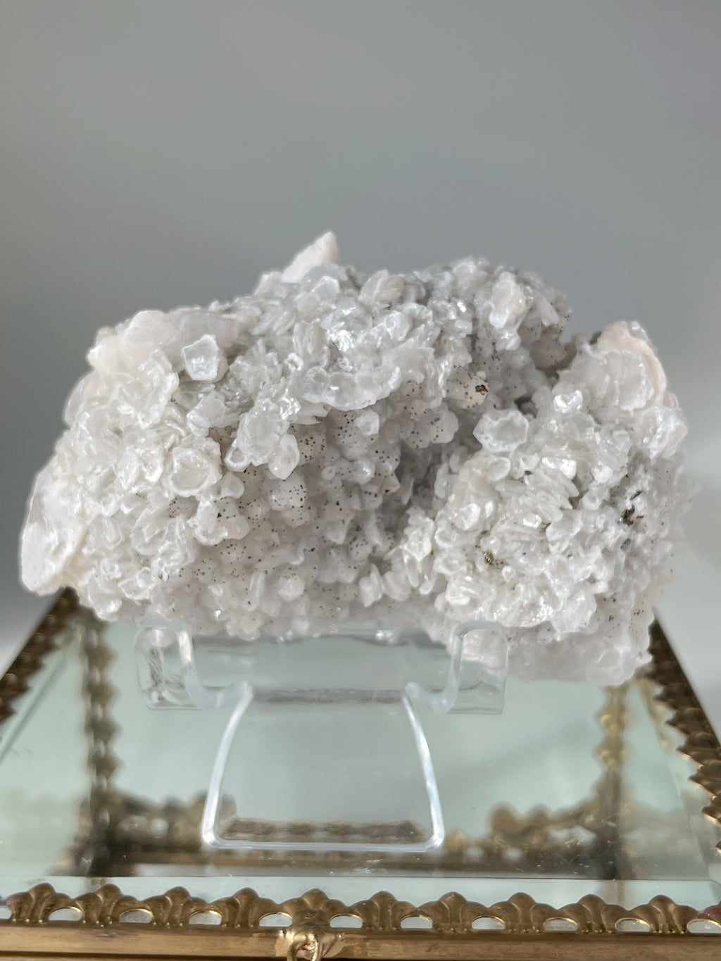 Beautiful crystal specimen featuring pyrite and calcite on quartz, displayed on a decorative stand.