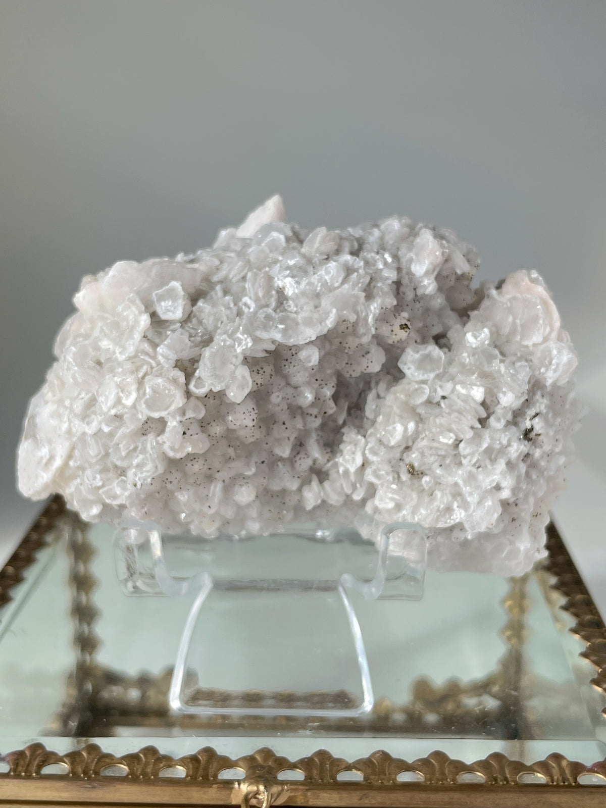Beautiful crystal specimen featuring pyrite and calcite on quartz, displayed on a decorative stand.