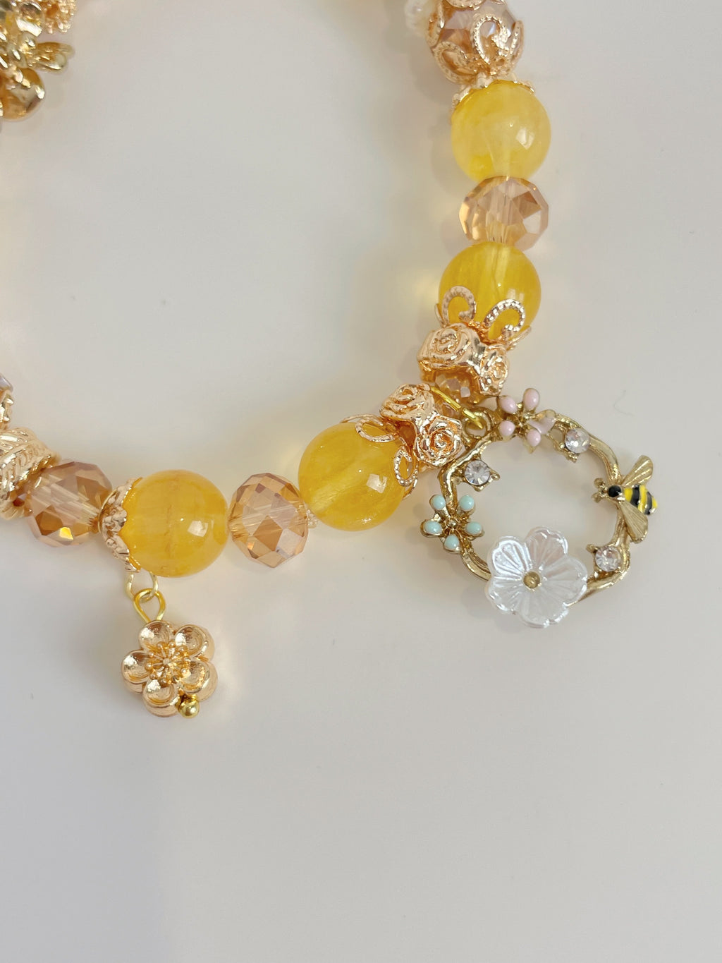 Beautiful yellow fluorite bracelet featuring 9mm beads, floral accents, and sparkling crystal details.