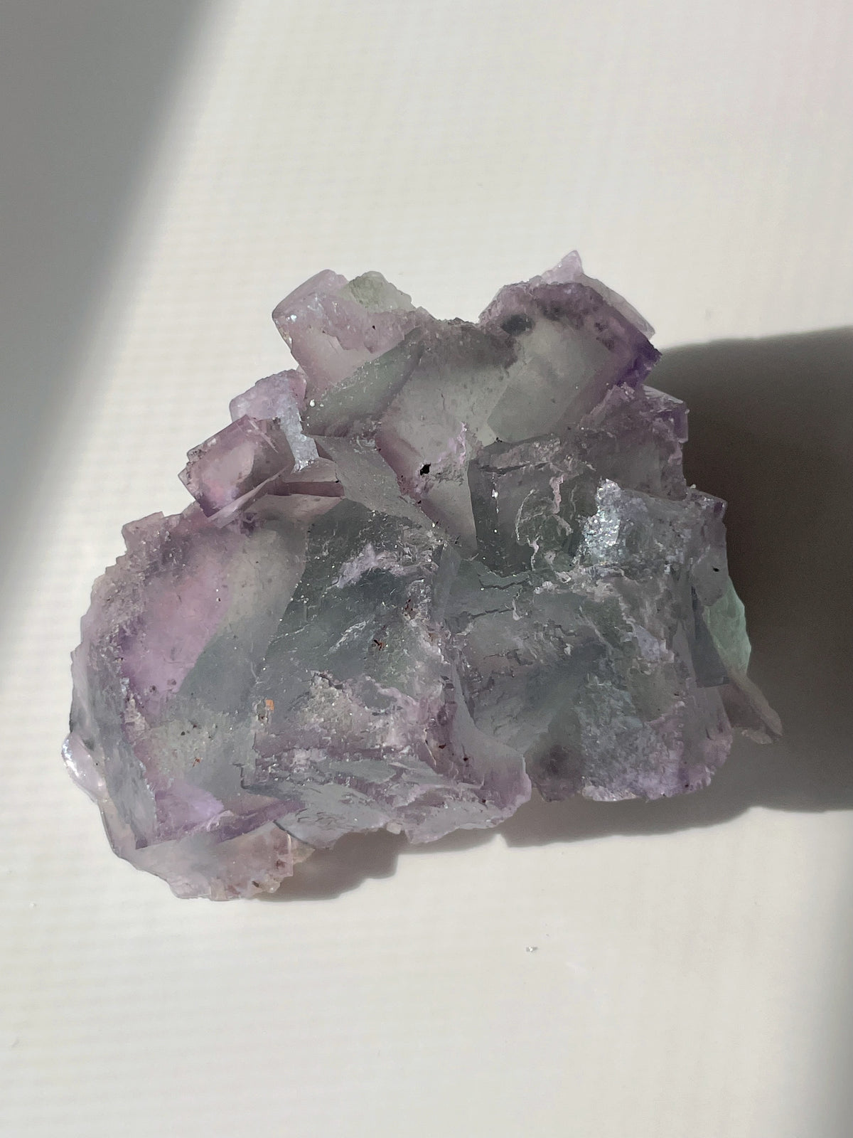 Beautiful fluorite crystal specimen featuring shades of purple and green, showcasing natural formations.
