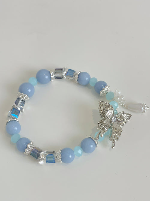 Beautiful bracelet featuring light blue beads, silver butterfly charm, and decorative accents.