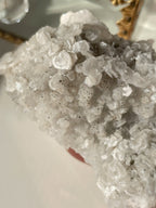 A stunning specimen of pyrite and calcite on quartz, showcasing intricate crystal formations and a shimmering surface.