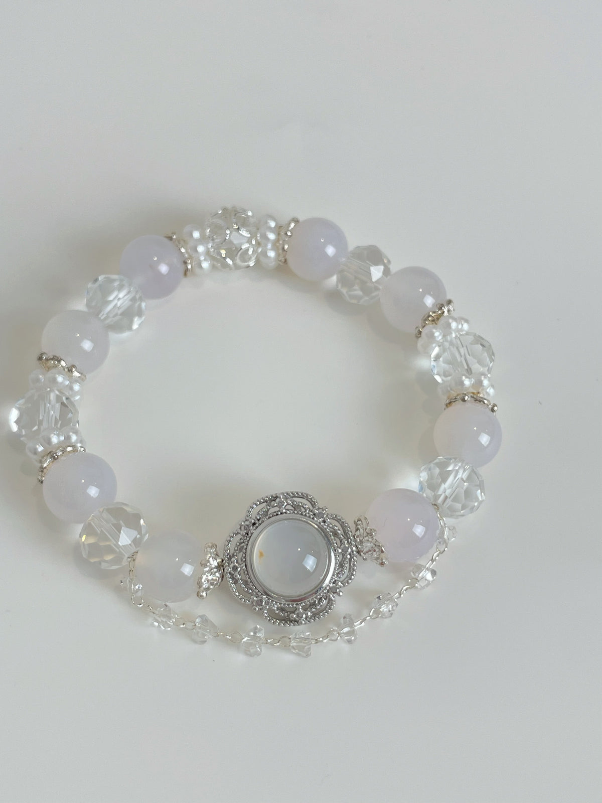 Elegant white agate bracelet featuring 10mm beads, adorned with sparkling crystal accents and a decorative centerpiece.