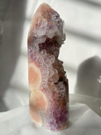 A stunning purple and pink amethyst crystal tower with intricate formations and natural textures.