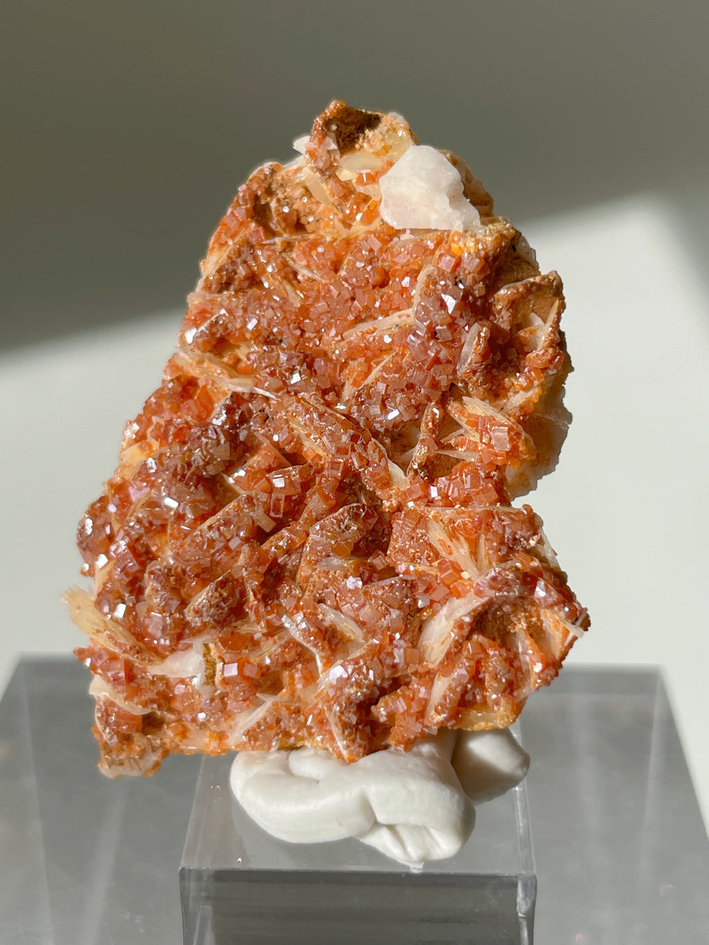 Stunning Moroccan vanadinite crystal specimen on a white barite base, showcasing vibrant orange-red hues.