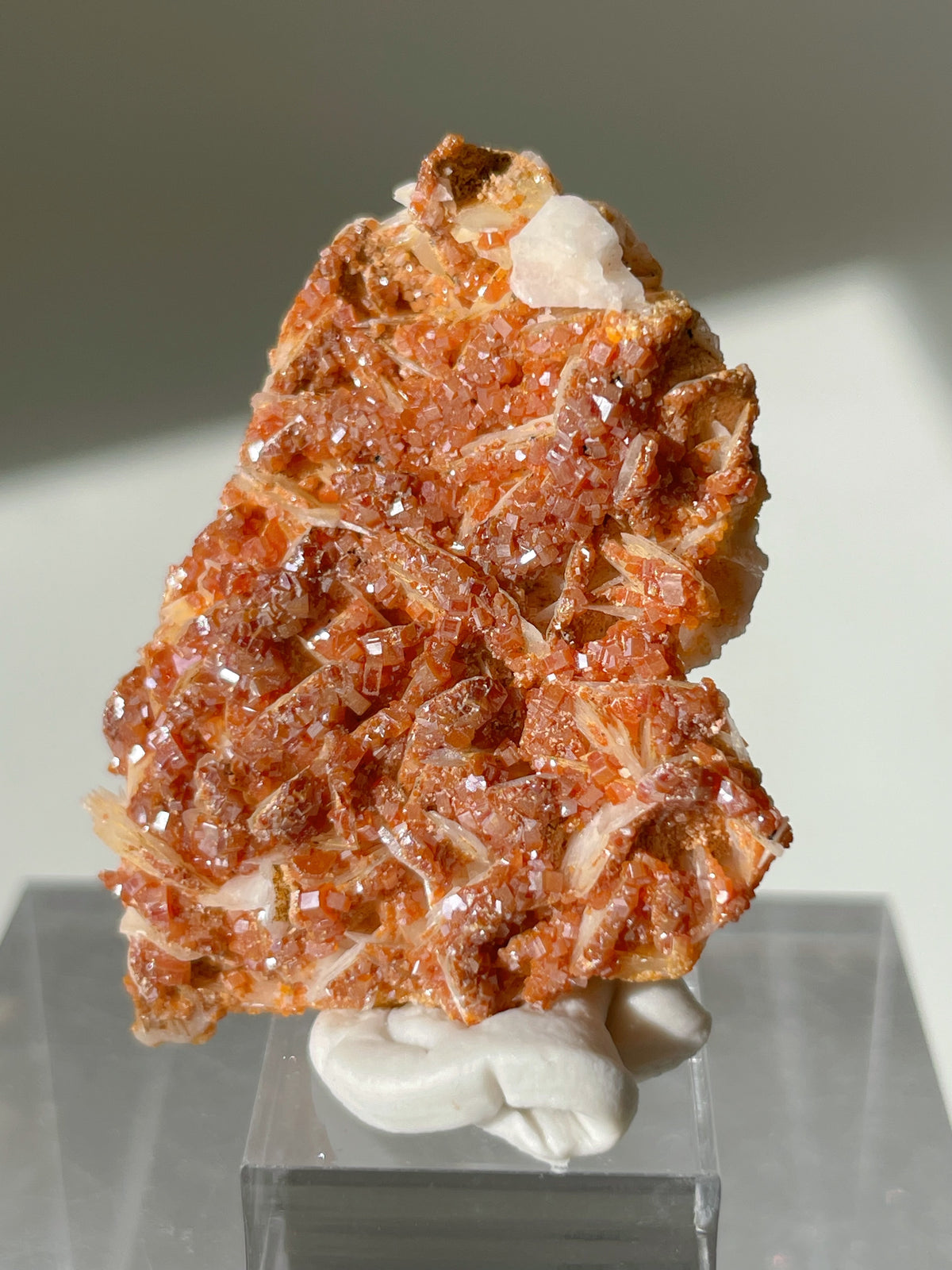 Stunning Moroccan vanadinite crystal specimen on a white barite base, showcasing vibrant orange-red hues.